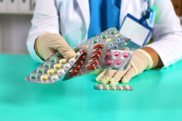 Kvinnlig läkare håller i en förpackning med olika tablettblister på arbetsplatsen. Panacea, livräddning tjänst, ordinera läkemedel, laglig apotek, sjukdom healing, blodtryck koncept. Brevlådevy — Stockfoto