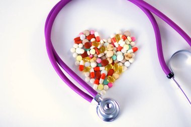 Stetoskop ve beyaz arka planda izole edilmiş bazı haplar.