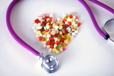 Stetoskop ve beyaz arka planda izole edilmiş bazı haplar.