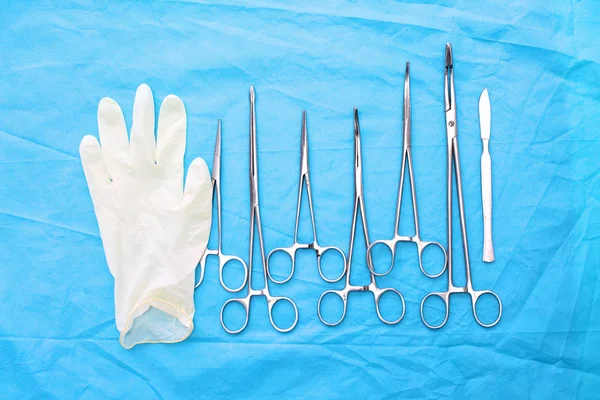 surgical instruments and tools including scalpels, forceps and tweezers arranged on a table for a surgery