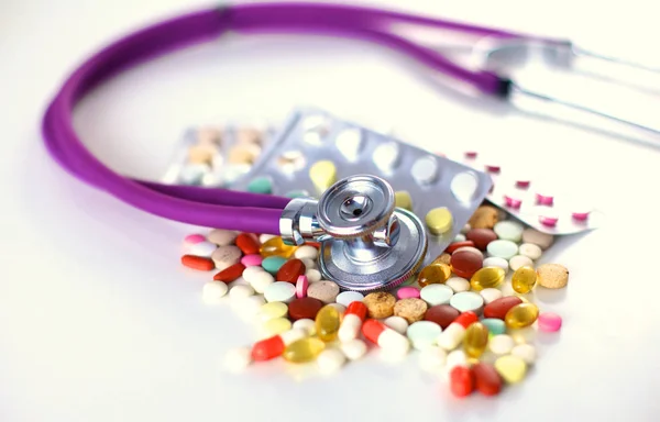 Stetoskop a nějaké pilulky - izolované na bílém pozadí — Stock fotografie