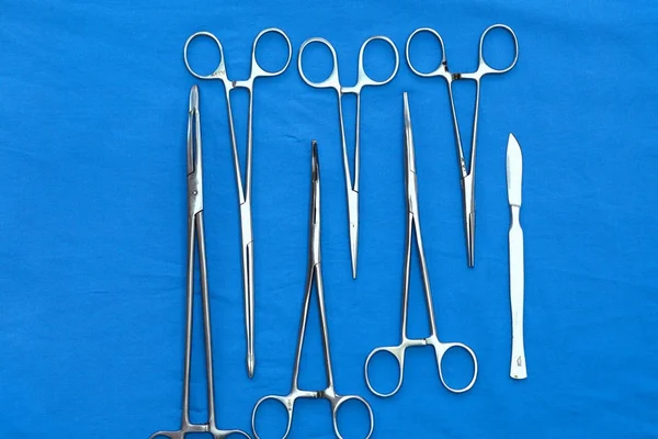 Instruments et outils chirurgicaux, y compris scalpels, pinces et pinces à épiler, disposés sur une table pour une intervention chirurgicale — Photo