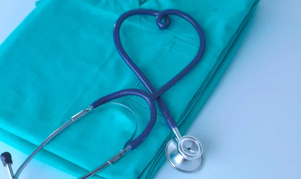 Estetoscopio en una mesa con uniforme médico —  Fotos de Stock