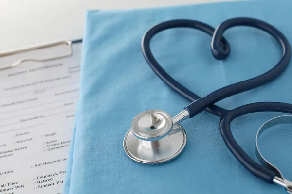 Estetoscopio en una mesa con uniforme médico —  Fotos de Stock