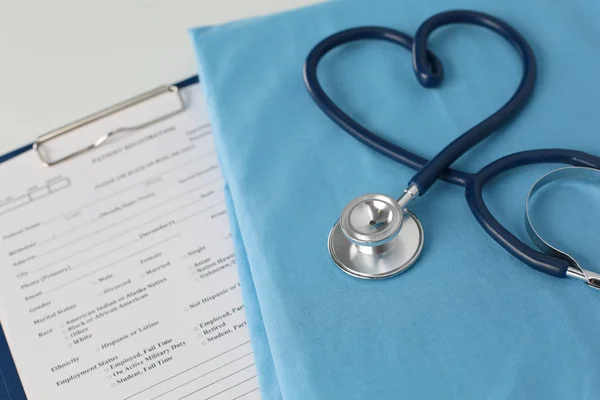 Estetoscópio em uma mesa com uniforme médico — Fotografia de Stock