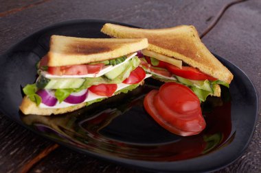 Sağlıklı sandviç yumuşak peynir ve çiğ bahar sebzeler gevrek siyah ekmek üzerinde