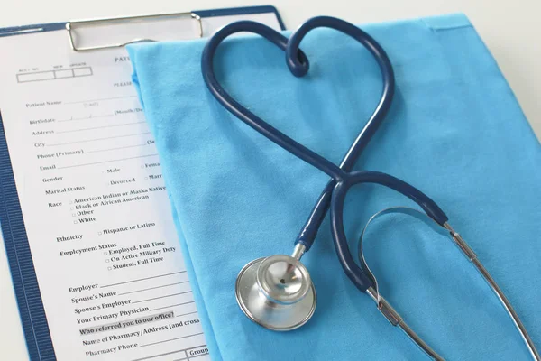 Estetoscopio en una mesa con uniforme médico — Foto de Stock