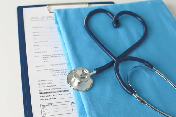 Estetoscopio en una mesa con uniforme médico —  Fotos de Stock