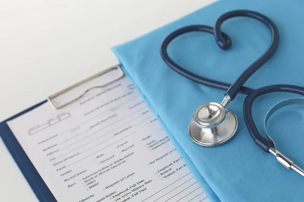 Estetoscopio en una mesa con uniforme médico — Foto de Stock