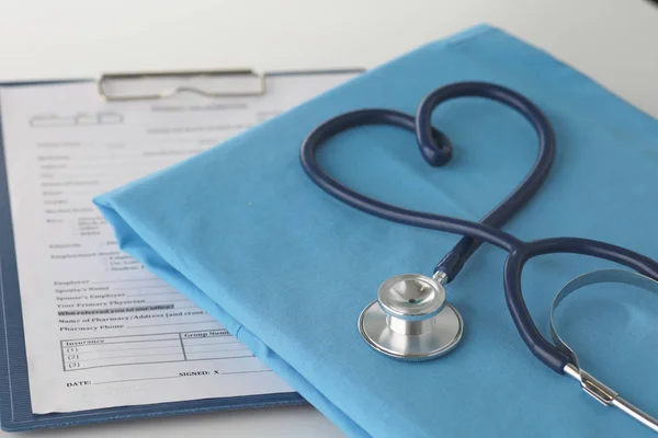 Estetoscopio en una mesa con uniforme médico —  Fotos de Stock