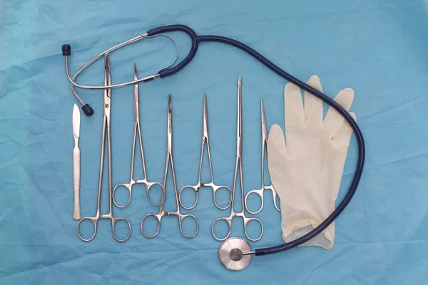 Instrumentos e ferramentas cirúrgicos, incluindo bisturis, pinças e pinças dispostos em uma mesa para uma cirurgia — Fotografia de Stock