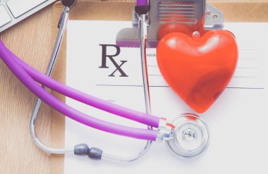 Beyaz ahşap bir masa üstünde a laptop yanında sağlık stetoskop