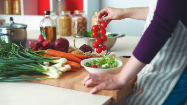 Genç kadın mutfakta yemek pişiriyor. Sağlıklı Yemek