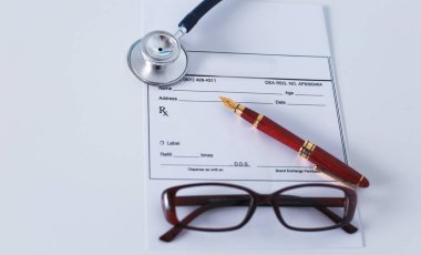 Doktorların çalışma alanı çalışma tablosu hastalar deşarj boş kağıt formu, tıbbi reçete, stetoskop üstünde okul sırası ile