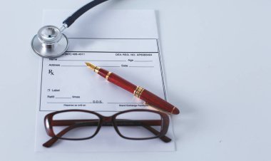 Doktorların çalışma alanı çalışma tablosu hastalar deşarj boş kağıt formu, tıbbi reçete, stetoskop üstünde okul sırası ile