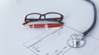 Doktorların çalışma alanı çalışma tablosu hastalar deşarj boş kağıt formu, tıbbi reçete, stetoskop üstünde okul sırası ile