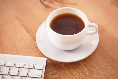 Ofis dizüstü bilgisayar, not defteri ve kahve masa üstü görünümüyle çalışma
