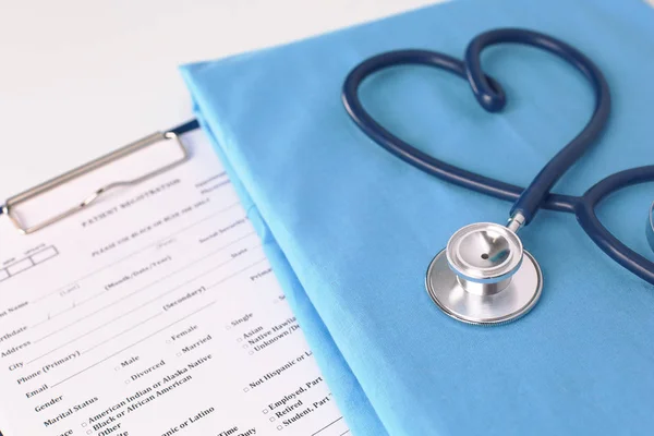 Un estetoscopio dando forma a un corazón en un uniforme médico, primer plano —  Fotos de Stock