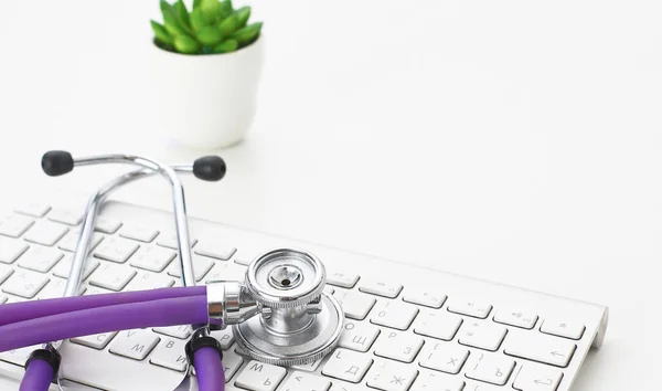 A stethoscope is on the keyboard of a computer — Stock Photo, Image