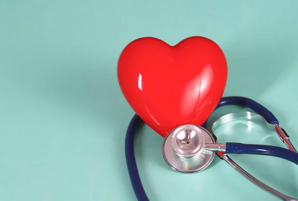 Rött hjärta med stetoskop på blå trä bakgrund. Kopiera utrymme. Alla hjärtans dag. — Stockfoto