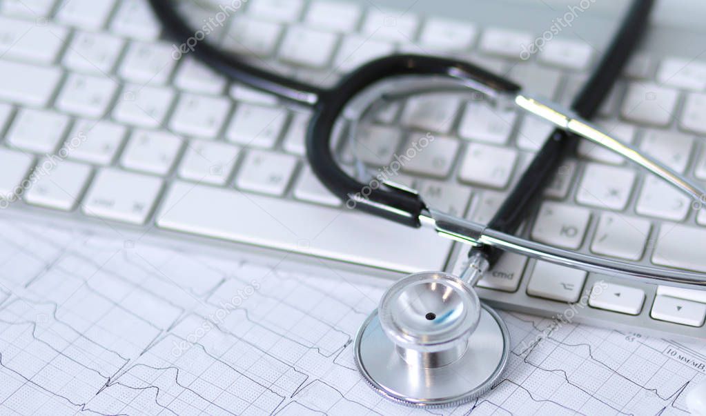 A stethoscope is on the keyboard of a computer