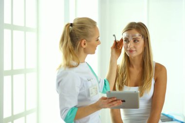 Kalıcı makyaj kaşları için. Güzellik Salonu içinde kalın kaşları ile güzel bir kadın. Şevval Özçelik Güzellik kadın yüzü için kaş dövme yapıyor. Güzellik yordamı