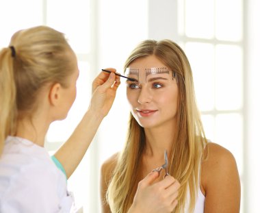 Kalıcı makyaj kaşları için. Güzellik Salonu içinde kalın kaşları ile güzel bir kadın. Şevval Özçelik Güzellik kadın yüzü için kaş dövme yapıyor. Güzellik yordamı