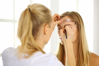 Kalıcı makyaj kaşları için. Güzellik Salonu içinde kalın kaşları ile güzel bir kadın. Şevval Özçelik Güzellik kadın yüzü için kaş dövme yapıyor. Güzellik yordamı