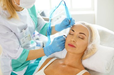 Kalıcı makyaj kaşları için. Güzellik Salonu içinde kalın kaşları ile güzel bir kadın. Şevval Özçelik Güzellik kadın yüzü için kaş dövme yapıyor. Güzellik yordamı