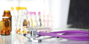 bir doktor ofisi ile bir stetoskop ön planda ve arka planda hapları bir şişeyle Resepsiyon closeup
