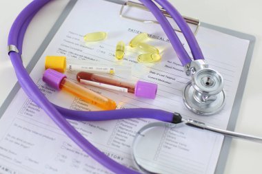bir doktor ofisi ile bir stetoskop ön planda ve arka planda hapları bir şişeyle Resepsiyon closeup