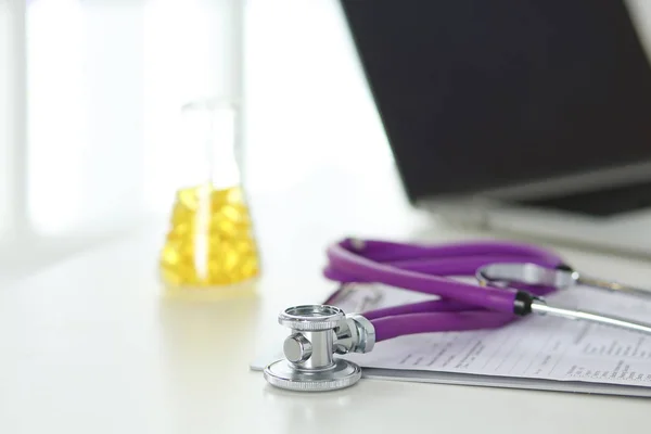 Bir doktor ofisi ile bir stetoskop ön planda ve arka planda hapları bir şişeyle Resepsiyon closeup — Stok fotoğraf