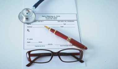 Doktorların çalışma alanı çalışma tablosu hastalar deşarj boş kağıt formu, tıbbi reçete, stetoskop üstünde okul sırası ile