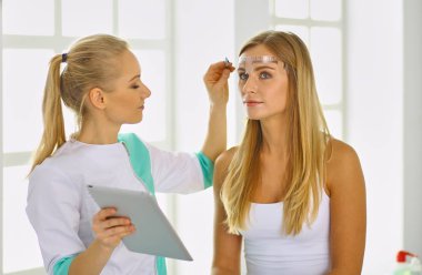 Kalıcı makyaj kaşları için. Güzellik Salonu içinde kalın kaşları ile güzel bir kadın. Şevval Özçelik Güzellik kadın yüzü için kaş dövme yapıyor. Güzellik yordamı