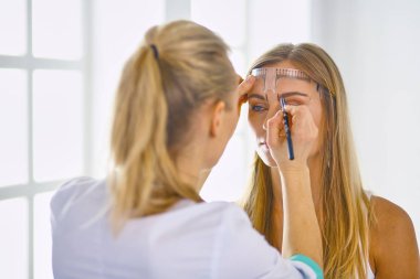 Kalıcı makyaj kaşları için. Güzellik Salonu içinde kalın kaşları ile güzel bir kadın. Şevval Özçelik Güzellik kadın yüzü için kaş dövme yapıyor. Güzellik yordamı