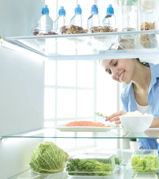 オープン冷蔵庫の前に野菜と幸せな女 — ストック写真