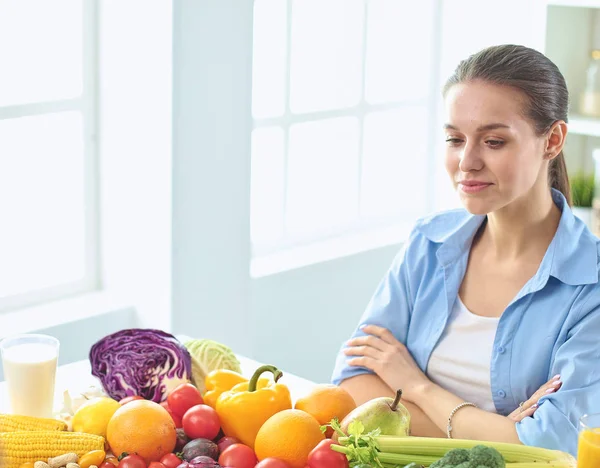 Glad Ung hemmafru sitter i köket förbereder mat från en hög med olika färska ekologiska frukter och grönsaker — Stockfoto