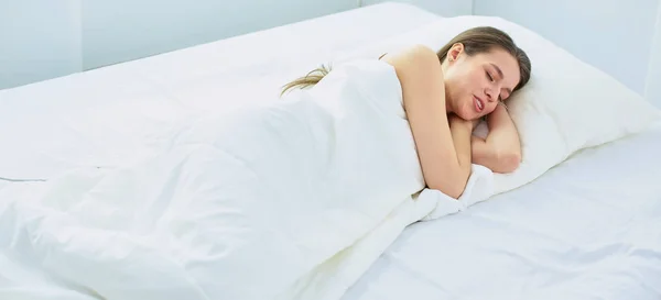 Jovem beleza dormindo em uma cama branca — Fotografia de Stock