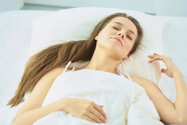 Joven belleza dormido en una cama blanca — Foto de Stock