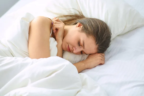 Jovem beleza dormindo em uma cama branca — Fotografia de Stock