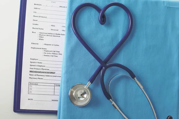 Estetoscopio en una mesa con uniforme médico —  Fotos de Stock