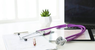 bir doktor ofisi ile bir stetoskop ön planda ve arka planda hapları bir şişeyle Resepsiyon closeup