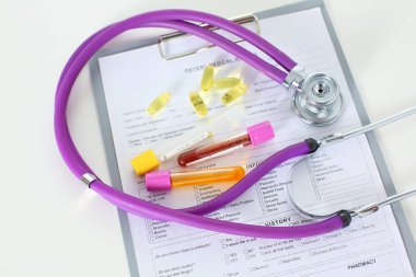 bir doktor ofisi ile bir stetoskop ön planda ve arka planda hapları bir şişeyle Resepsiyon closeup