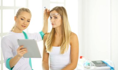 Kalıcı makyaj kaşları için. Güzellik Salonu içinde kalın kaşları ile güzel bir kadın. Şevval Özçelik Güzellik kadın yüzü için kaş dövme yapıyor. Güzellik yordamı