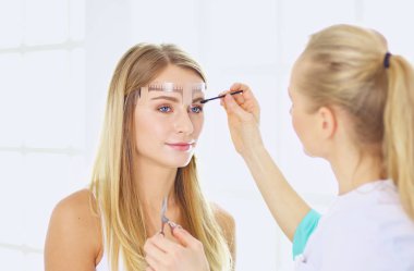 Kalıcı makyaj kaşları için. Güzellik Salonu içinde kalın kaşları ile güzel bir kadın. Şevval Özçelik Güzellik kadın yüzü için kaş dövme yapıyor. Güzellik yordamı