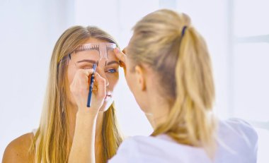 Kalıcı makyaj kaşları için. Güzellik Salonu içinde kalın kaşları ile güzel bir kadın. Şevval Özçelik Güzellik kadın yüzü için kaş dövme yapıyor. Güzellik yordamı