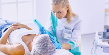 Kalıcı makyaj kaşları için. Güzellik Salonu içinde kalın kaşları ile güzel bir kadın. Şevval Özçelik Güzellik kadın yüzü için kaş dövme yapıyor. Güzellik yordamı