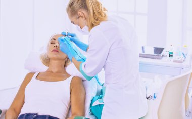 Kalıcı makyaj kaşları için. Güzellik Salonu içinde kalın kaşları ile güzel bir kadın. Şevval Özçelik Güzellik kadın yüzü için kaş dövme yapıyor. Güzellik yordamı