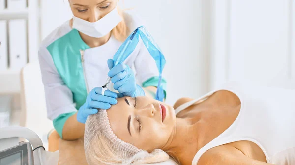Permanent Makeup For Eyebrows. Beautiful Woman With Thick Brows In Beauty Salon. Beautician Doing Eyebrow Tattooing For Female Face. Beauty Procedure — Stock Photo, Image