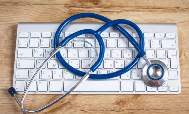 Doktorlar işyeri bilgisayar klavye, stetoskop ve gözlük